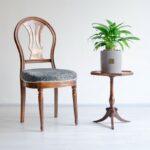 گلدان آپارتمانی اسپاتی فیلوم در کنار صندلی روی میز