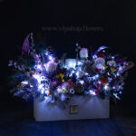 باکس گل کریسمسی سفید در شب می‌درخشد.