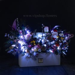 باکس گل کریسمسی سفید در شب می‌درخشد.