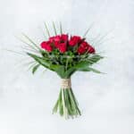 رزهای قرمز با چیدمان سبز حسی طبیعی را منتقل می‌کنند.