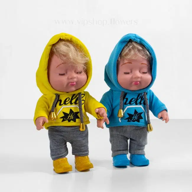 عروسک نوزاد با لباس آبی و زرد برای باکس گل گهواره نوزاد موجود است.