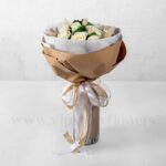 دسته‌گل رز سفید به همراه برگ و تزئینات لازم