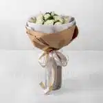 دسته‌گل رز سفید به همراه برگ و تزئینات لازم