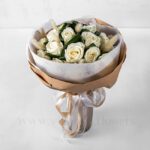 دسته‌گل رز سفید به همراه برگ و تزئینات لازم